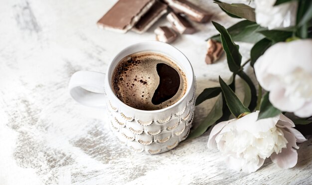 Natureza morta com uma xícara de café e flores