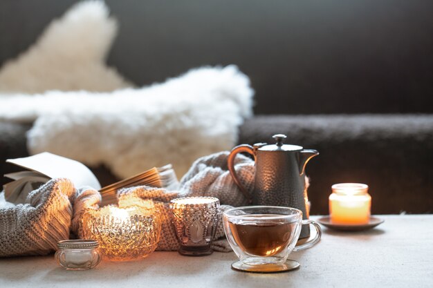 Natureza morta com uma xícara de chá, um bule e lindos castiçais vintage com velas.