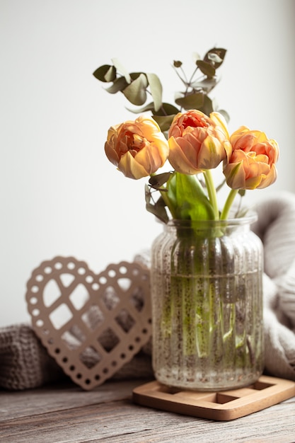 Natureza morta festiva com um arranjo de flores em um vaso e itens decorativos
