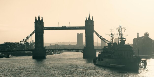 Navio de guerra HMS Belfast e Tower Bridge no Rio Tamisa em Londres