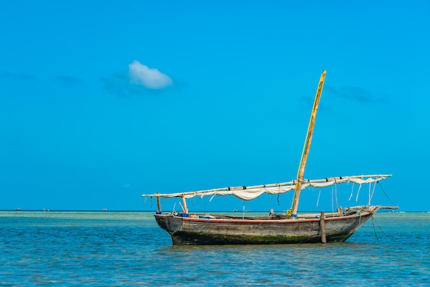 Navio de pesca na água do Oceano Índico na maré baixa. Zanzibar, Tanzânia