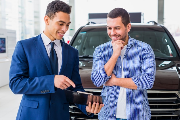 Negociante de carro falando ao cliente