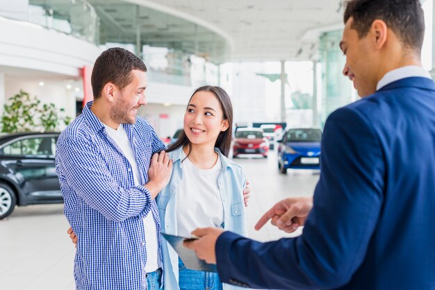 Negociante de carro falando com clientes