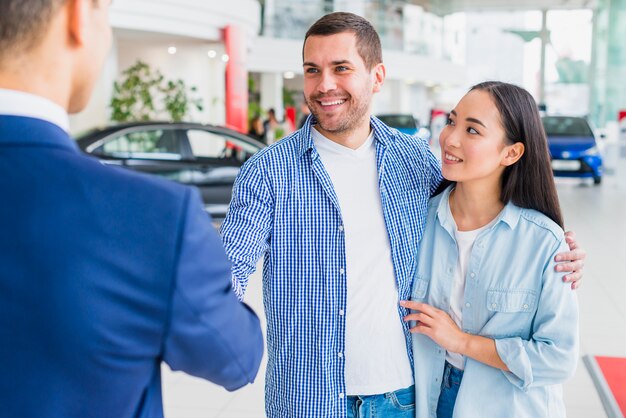 Negociante de carro falando com clientes