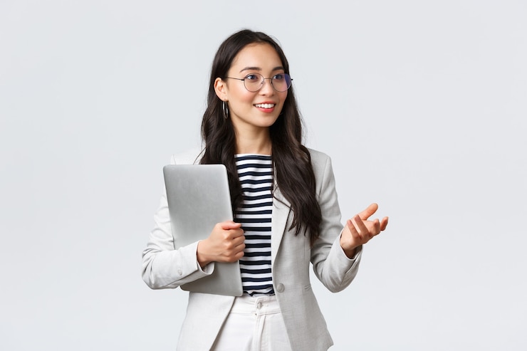 Foto grátis negócios, finanças e emprego, conceito de empresárias de sucesso feminino. sorridente empresária profissional, corretora de imóveis mostrando um bom negócio aos clientes, carrega o laptop na mão
