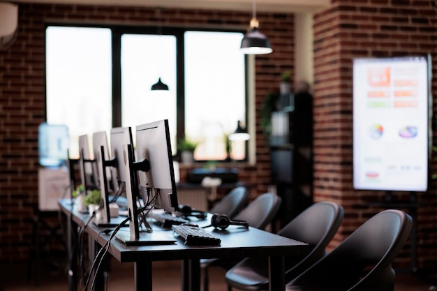 Foto grátis nenhuma pessoa no escritório com vários computadores no balcão de atendimento ao cliente, suporte de linha de apoio de call center para fornecer assistência de telecomunicações. helpdesk vazio com recepção de telefonia do cliente.