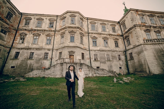 Newlyweds na frente de uma grande casa