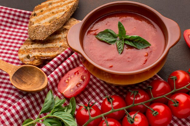 Ângulo alto de sopa de tomate de inverno em uma tigela com torrada e colher