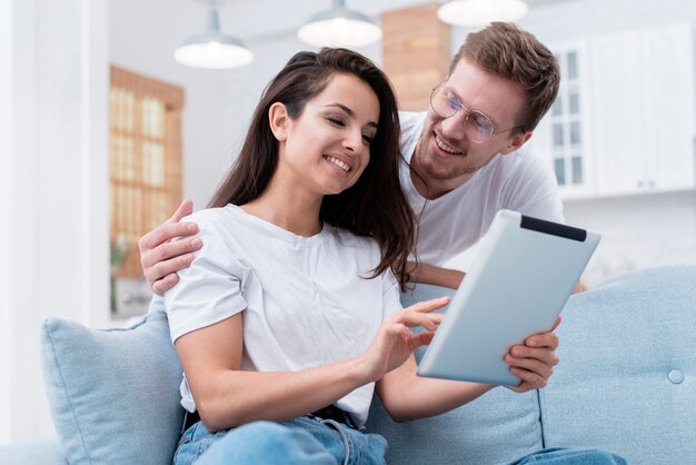 Ângulo baixo homem e mulher olhando no seu tablet