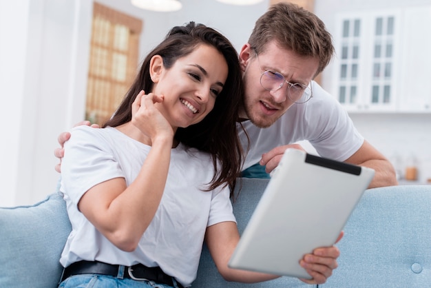 Ângulo baixo homem e mulher olhando no tablet