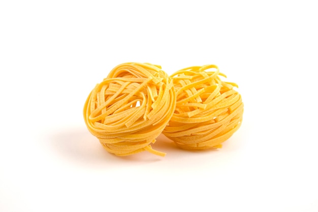 Ninhos de tagliatelle crus em branco.