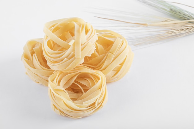 Ninhos de tagliatelle crus em branco.