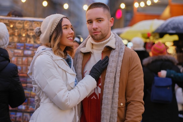 Foto grátis no tradicional mercado festivo, casal atraente aproveita o dia de natal enquanto tem um encontro.