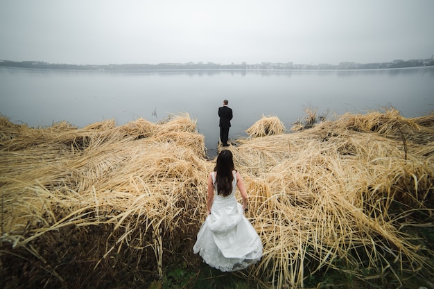 Noiva após o noivo no lago