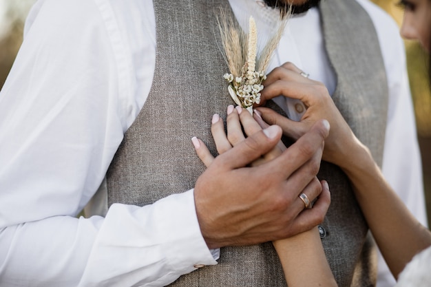 Foto grátis noiva colocando uma flor na lapela no elegante colete noivo