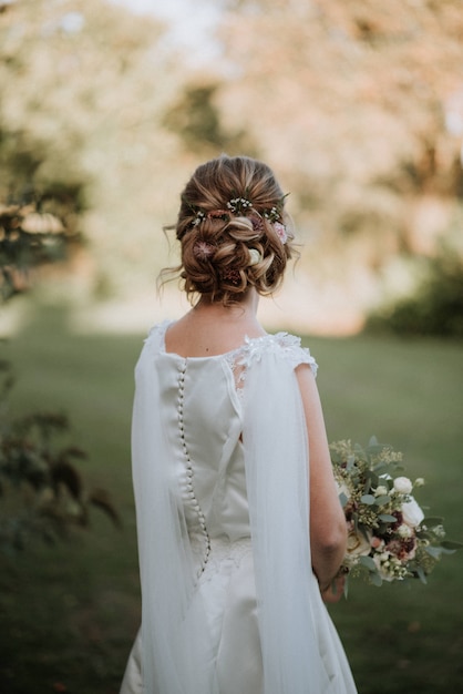 noiva com um penteado de noiva usando vestido de noiva, segurando um buquê de flores