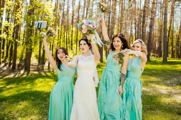 Noiva e damas de honra com buquês de casamento. momento alegre de recepção de casamento ensolarado.