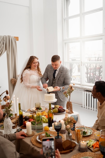 Noiva e noivo cortando o bolo em seu casamento