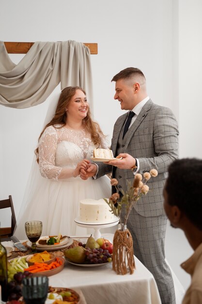 Noiva e noivo cortando o bolo em seu casamento