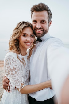 Noiva e noivo fazendo um casamento na praia