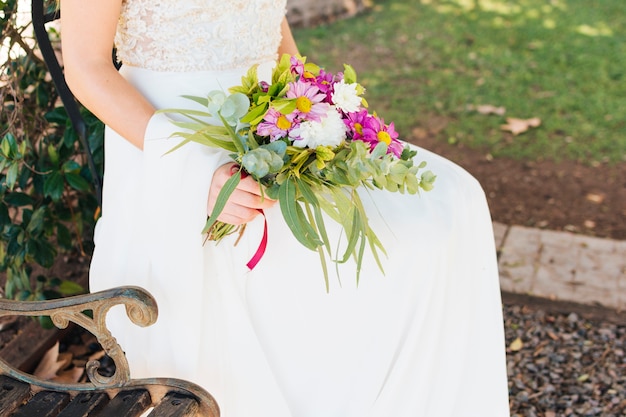 Noiva, em, vestido branco casamento, segurando, buquê flor, em, mão