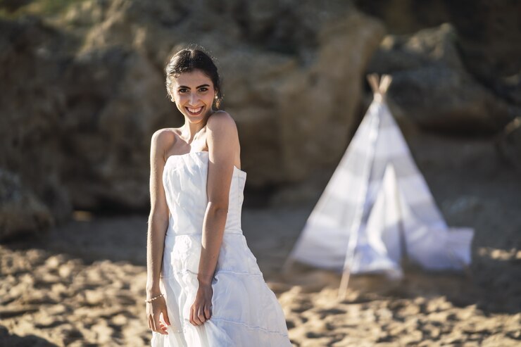 Foto grátis noiva morena caucasiana sorrindo enquanto posa na praia
