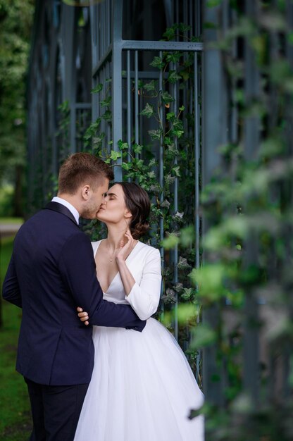 Noivas amorosas casal jovem snd mulher beijando aproveitando o dia do casamento ao ar livre Noiva perfeita no elegante elegante vestido de noiva inchado Cerimônia de casamento Casal ternura