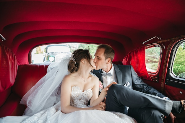 Noivas felizes estão se beijando no carro