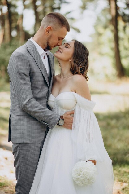 Noivo e noiva no dia do casamento na floresta