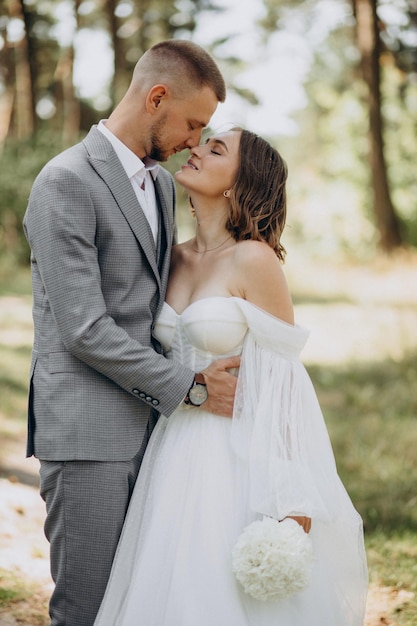 Noivo e noiva no dia do casamento na floresta