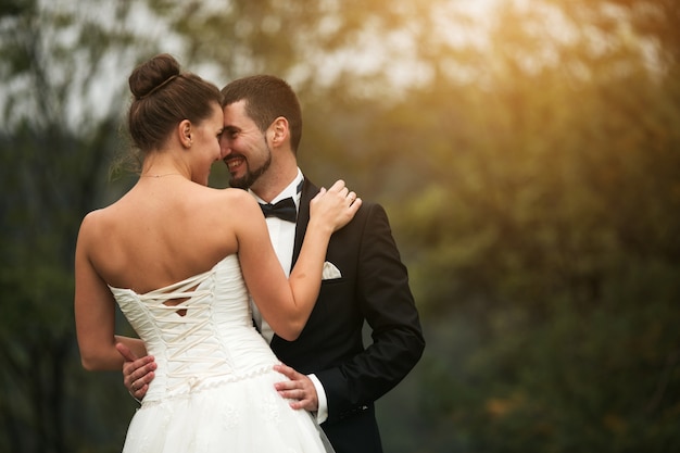 Foto grátis noivo feliz com mãos na cintura da noiva