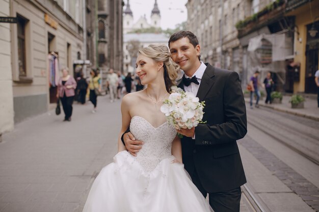 Noivo feliz com uma mão na cintura de sua esposa