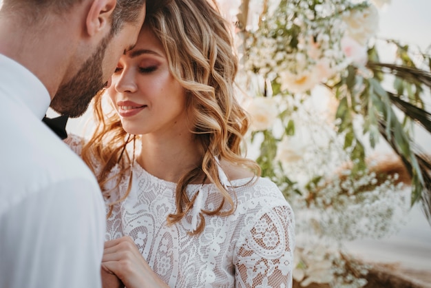 Foto grátis noivos lindos em um casamento na praia