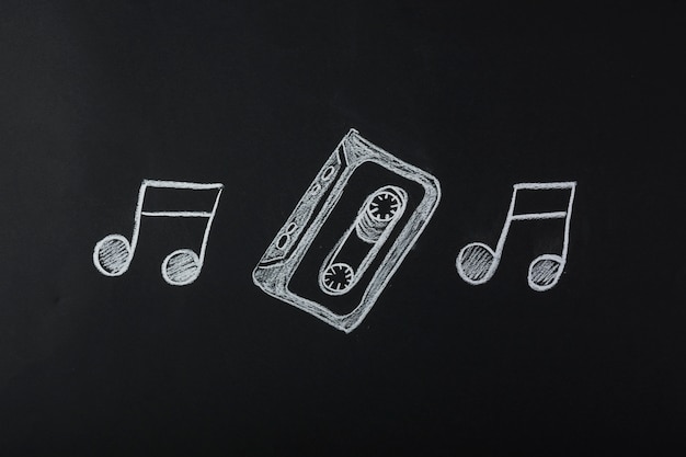 Foto grátis notas musicais desenhadas com fita cassete no quadro-negro