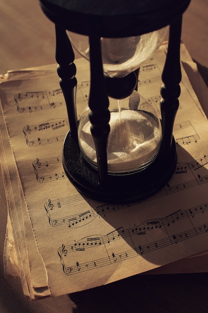 Foto grátis notas musicais em papéis e ampulheta