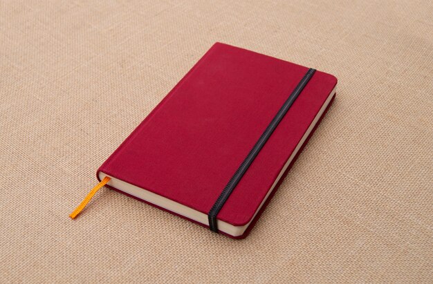 Notebook vermelho na superfície de tecido