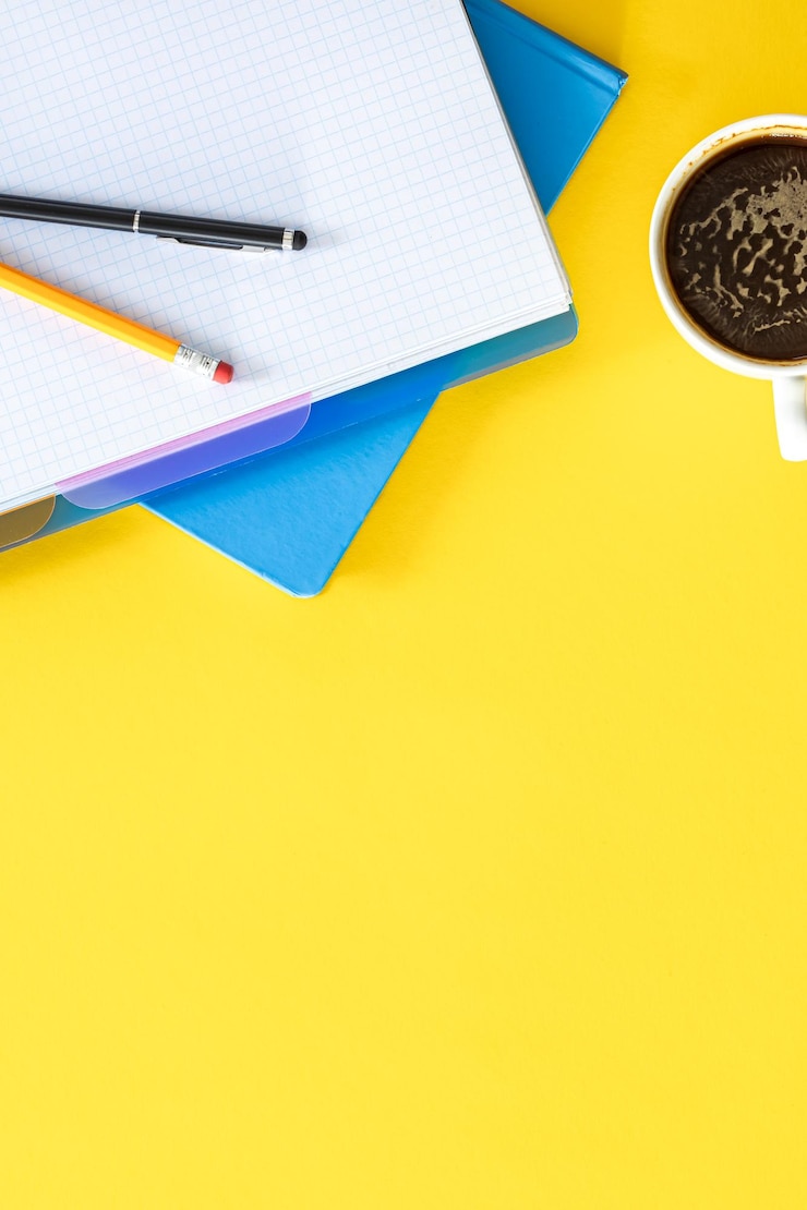 Foto grátis notepads e uma chávena de café em um plano de fundo amarelo