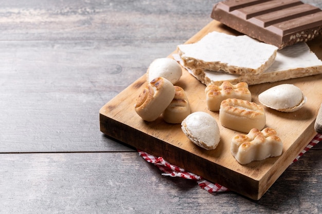 Foto grátis nougat doce tradicional de natal e amêndoas doces de natal em uma mesa de madeira