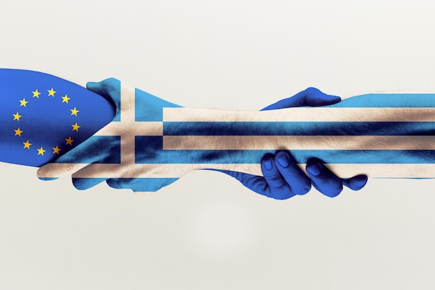 Novas chances. mãos masculinas segurando coloridas na bandeira azul da ue e da grécia isolada no fundo cinza do estúdio. conceito de ajuda, comunidade, parceria de países, relações políticas e econômicas.