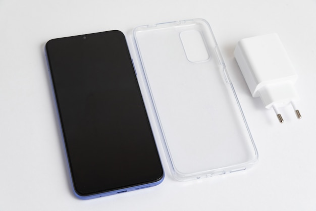 Novo celular e carregador com tampa transparente sobre fundo branco isolado
