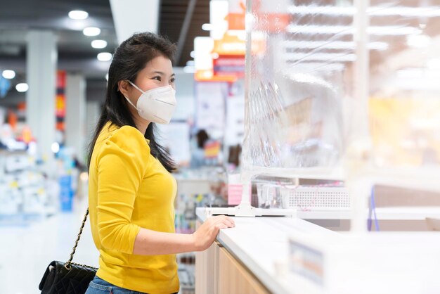 Novo normal após o progresso do pagamento feminino asiático da epidemia de covid comprar aplicativo de digitalização por smarthine sem dinheiro e novo estilo de vida sem toque compras no balcão de caixa da loja de departamentos