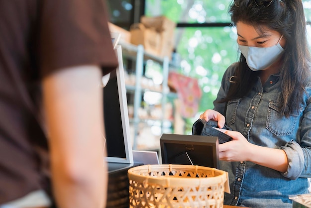 Novo normal após o progresso do pagamento feminino asiático da epidemia de covid comprar aplicativo de digitalização por smarthine sem dinheiro e novo estilo de vida sem toque compras no balcão de caixa da loja de departamentos