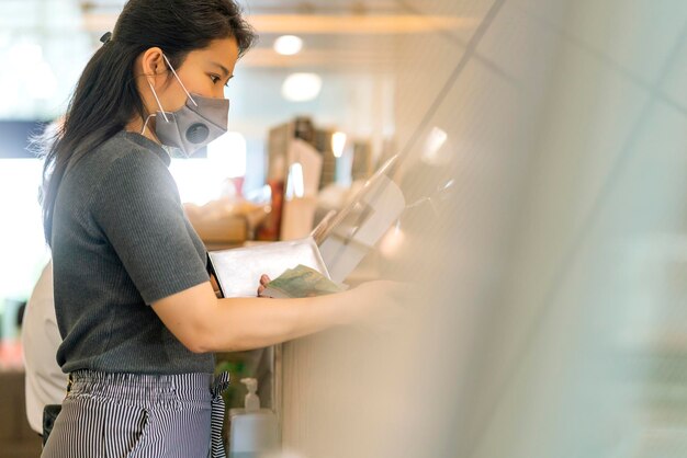 Novo normal após o progresso do pagamento feminino asiático da epidemia de covid comprar aplicativo de digitalização por smartphone sem dinheiro e sem toque novo estilo de vida compras no balcão de caixa da loja de café café