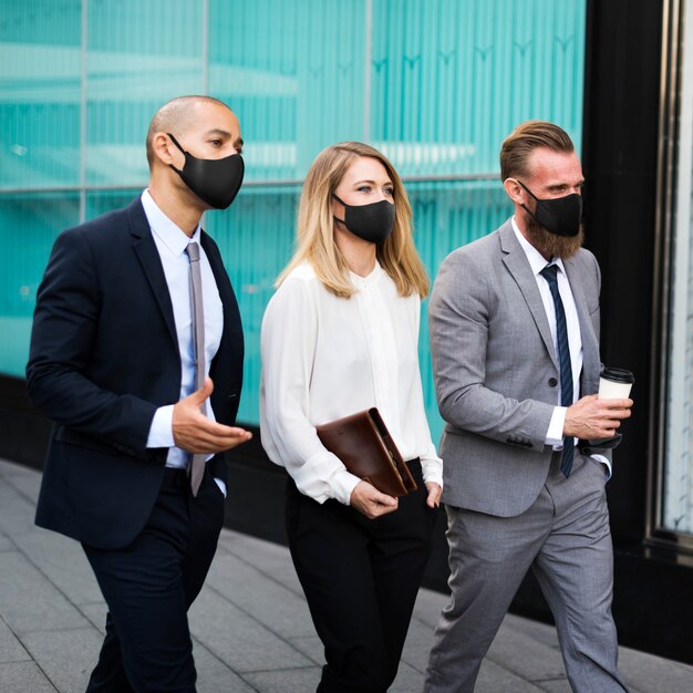 Novos executivos normais com máscaras faciais