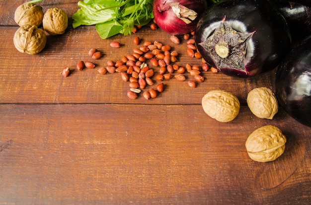Noz; amendoim e legumes no fundo texturizado de madeira marrom