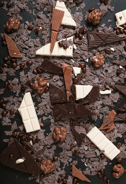 Nozes e grãos de café em pedaços de barra de chocolate