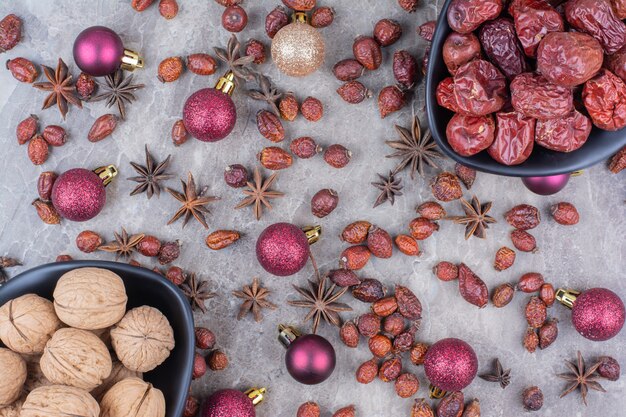 Nozes e roseiras em tigelas com bolas de Natal.