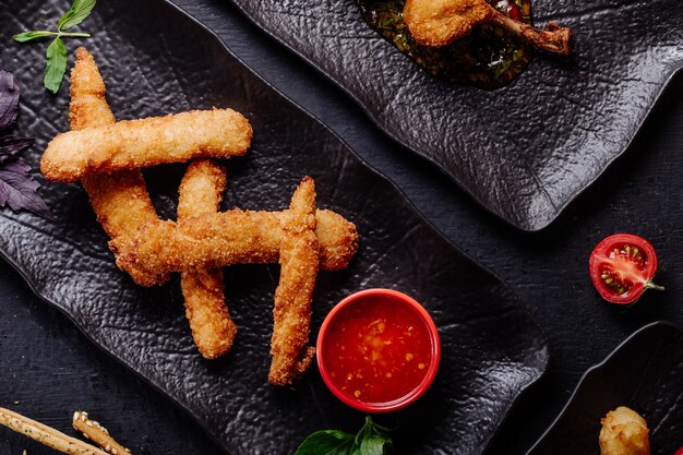 Nuggets de frango com molho de pimenta em chapa preta.