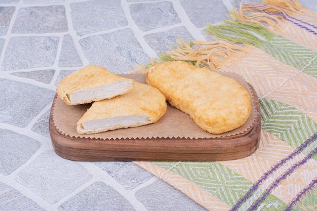 Nuggets de frango e peixe na placa de madeira.