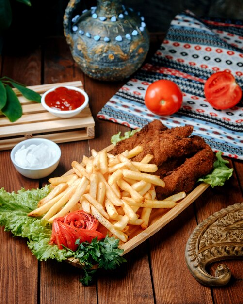 Nuggets de frango frito com batatas fritas na mesa